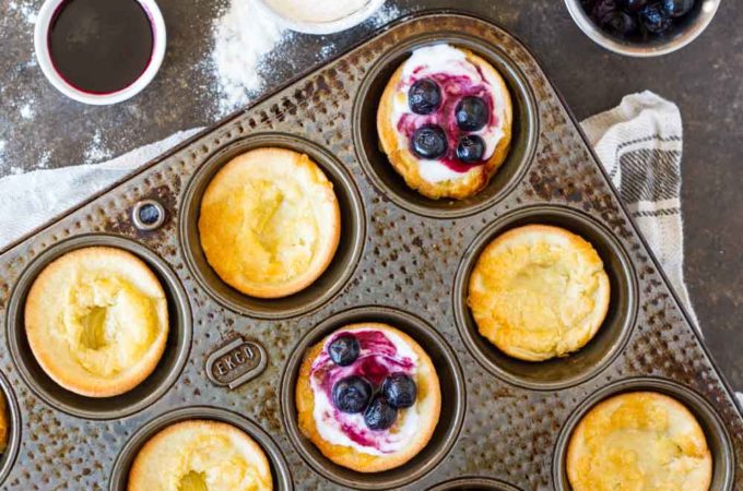 Mini Dutch Babies (gluten free, nut free, paleo) in muffin tins with blueberries