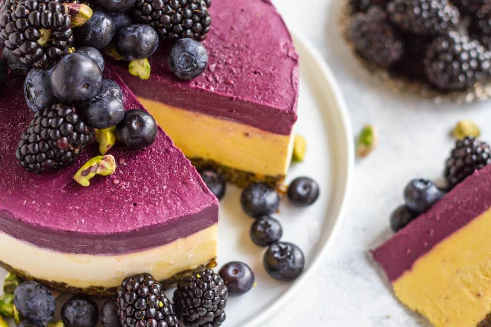 Mango Blackberry Cheesecake with slice cut out of it