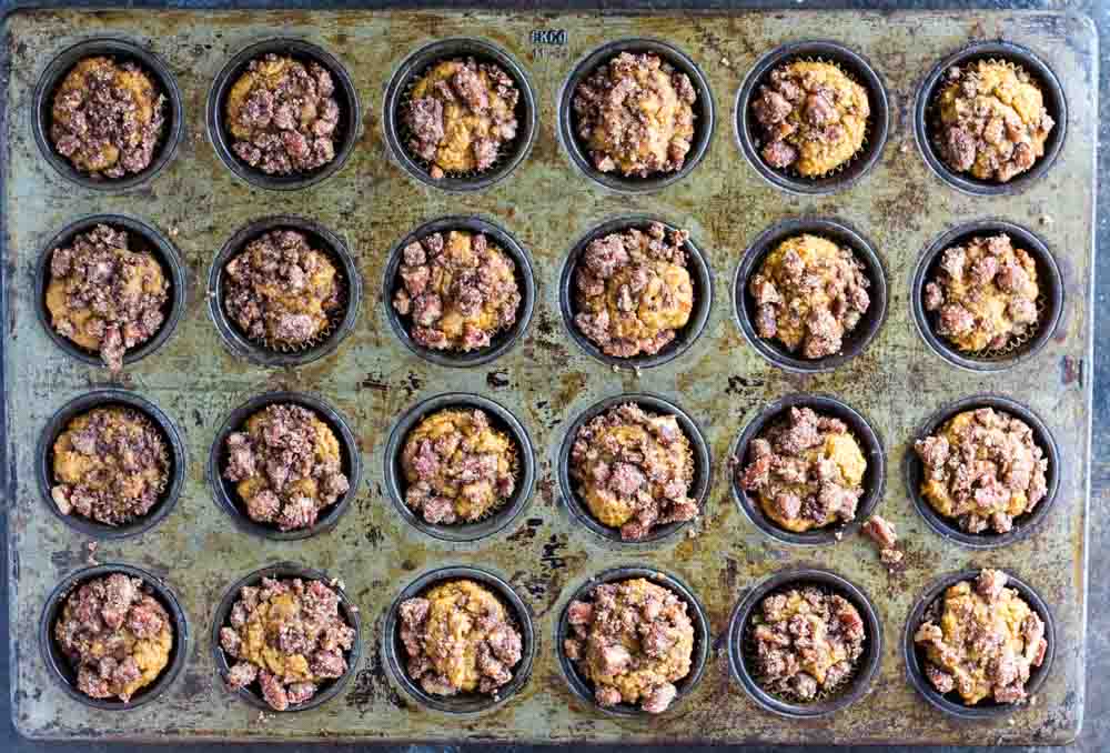 twenty four Mini Pumpkin Muffins in a baking tin
