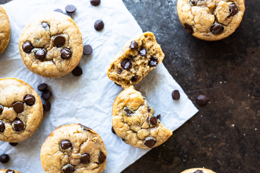 a muffin broken in half on parchment paper