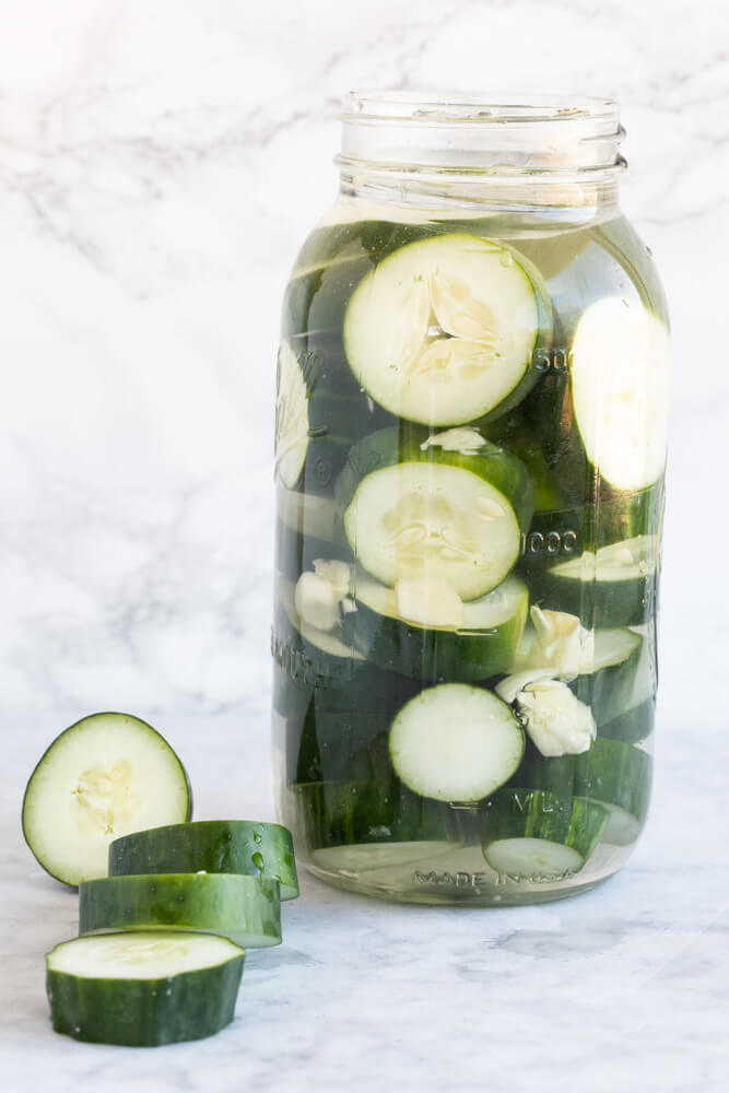 large mason jar with homemade pickles in brine