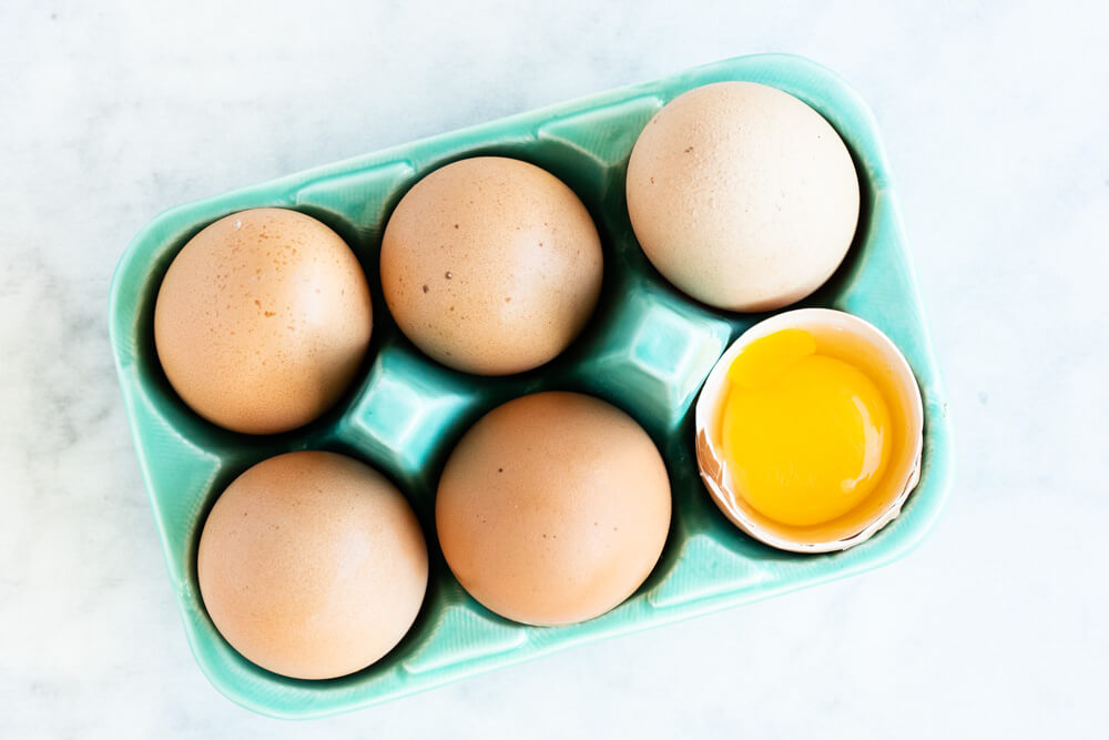 six eggs in a green carton