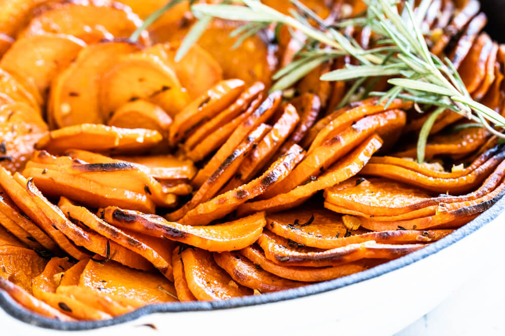 close up of sweet potato slices in white skillet