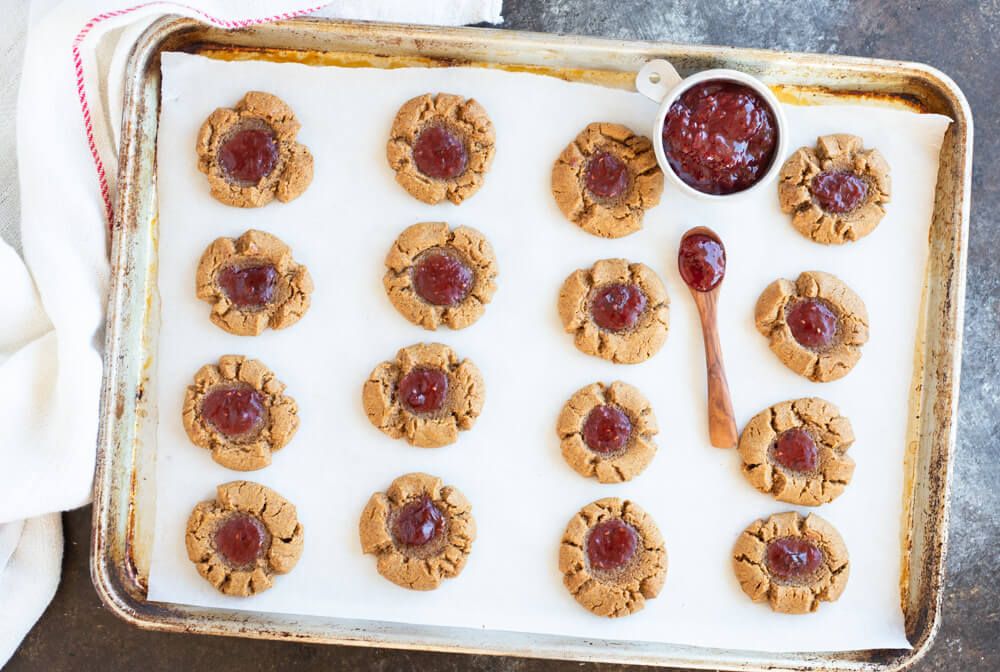 silver baking sheet with peanut butter and jelly thumbprints