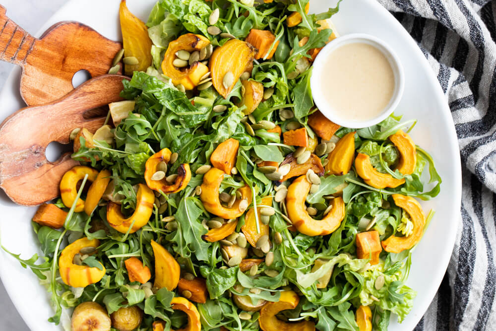 winter salad with roasted vegetables on white plate