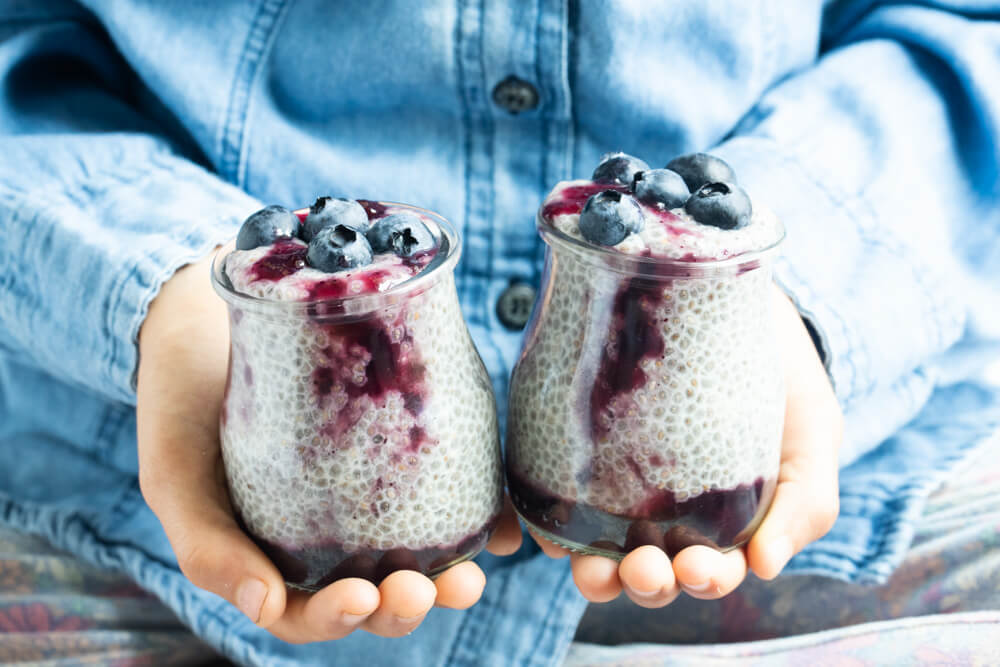 hands holding blueberry jam chia pudding