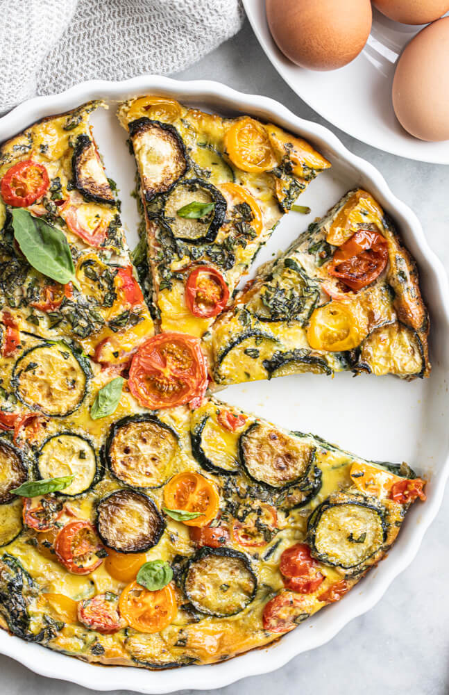 vegetable quiche sliced in white pan