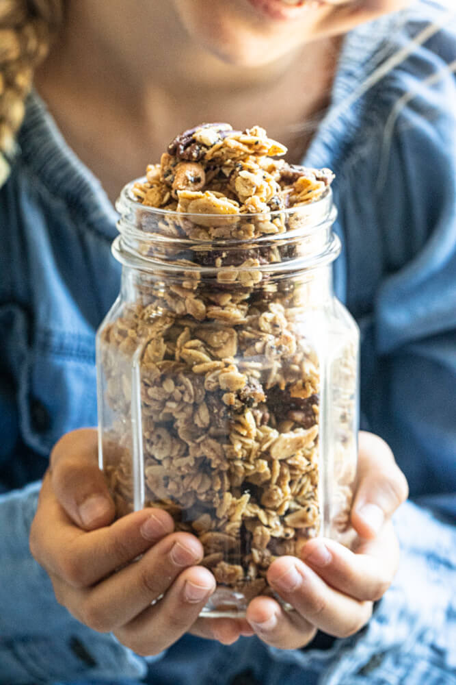 child holding glass jar of gluten free granola