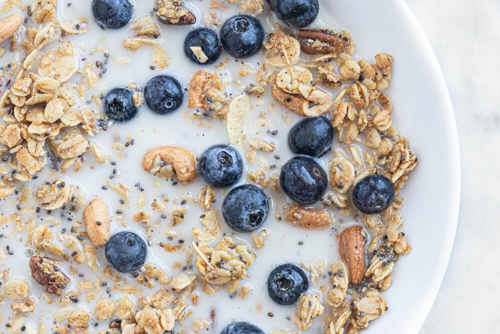 granola and milk in white bowl