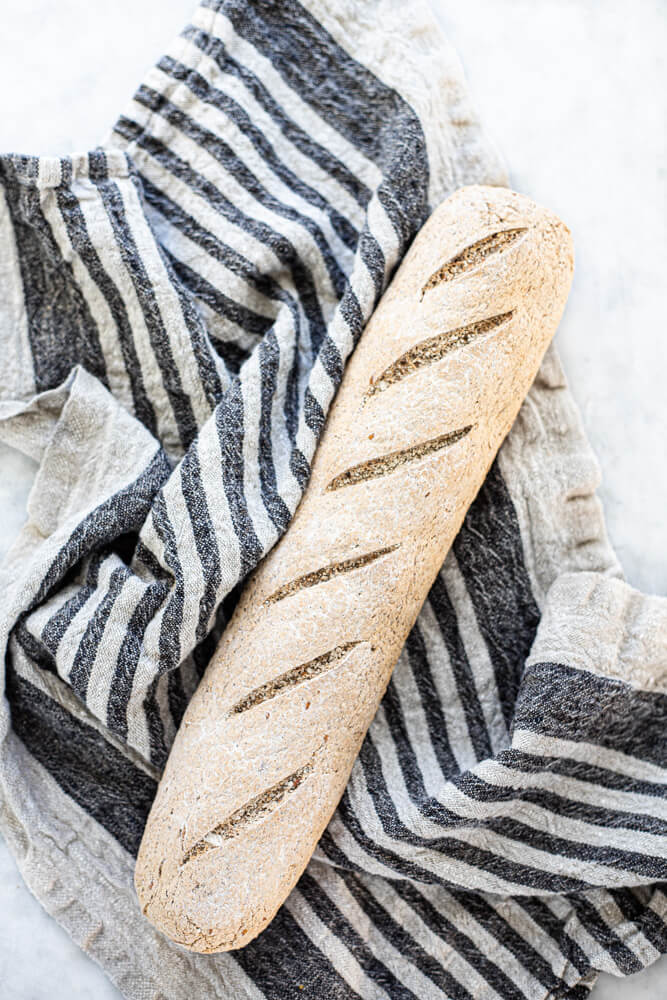 gluten free seeded sourdough baguette on white counter