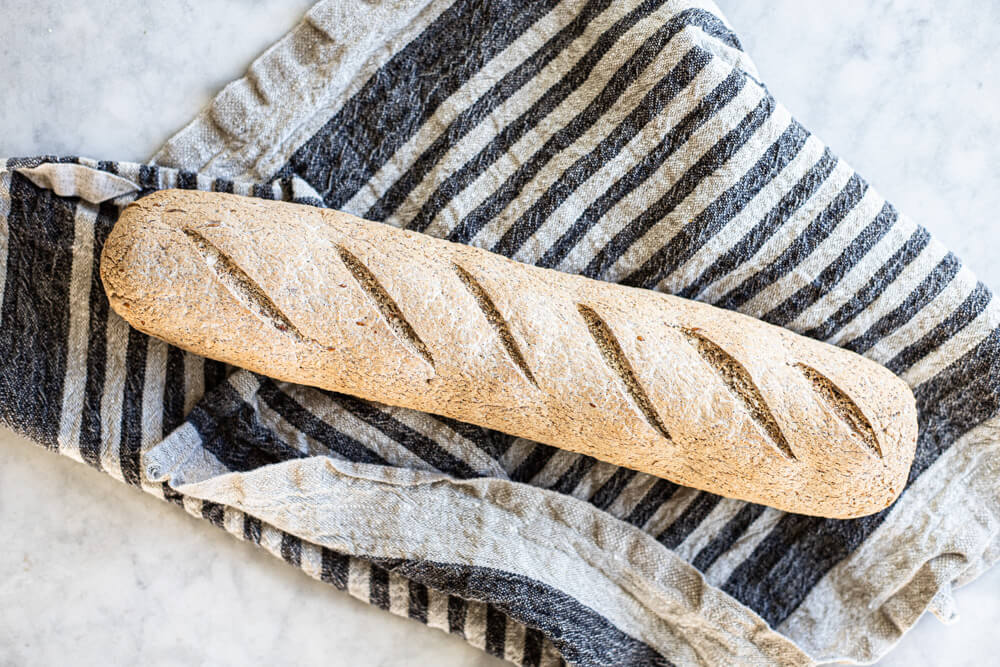 gluten free sourdough baguette on striped towel