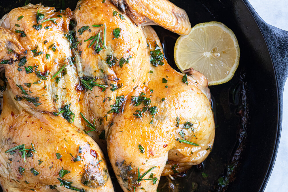 herbs and fresh lemon on whole chicken