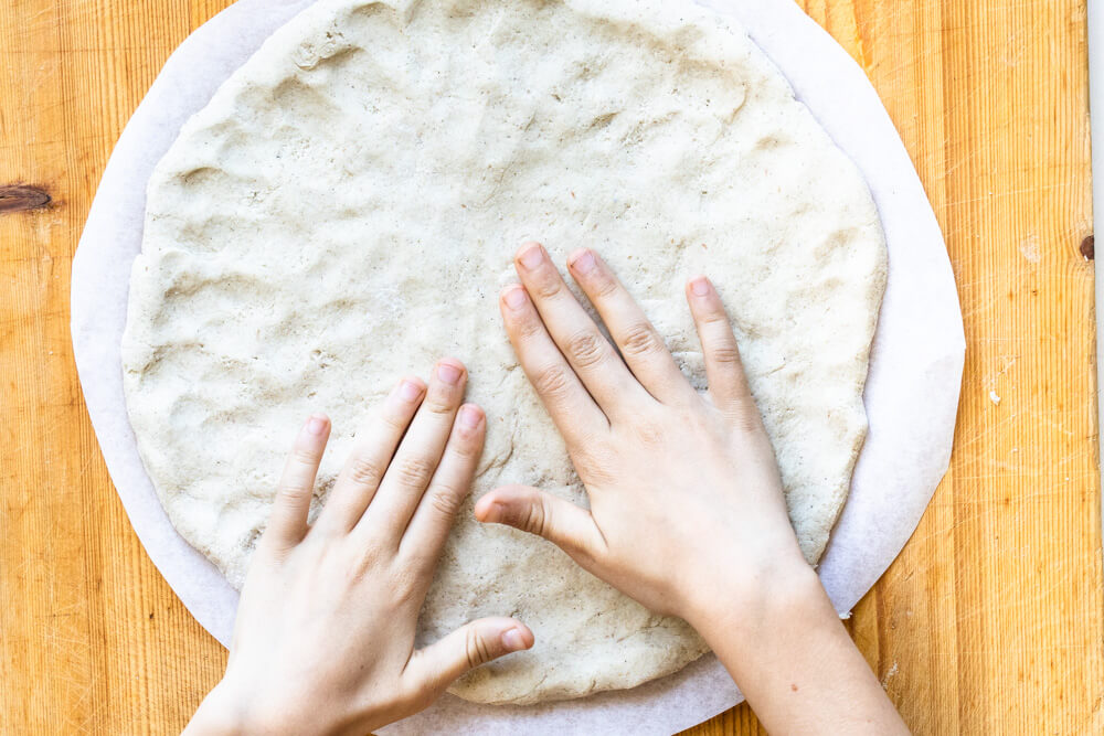 hands shaoing pizza dough