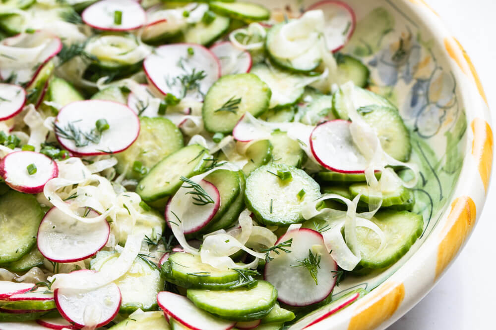 cucumbers and radishes in yellow bowl