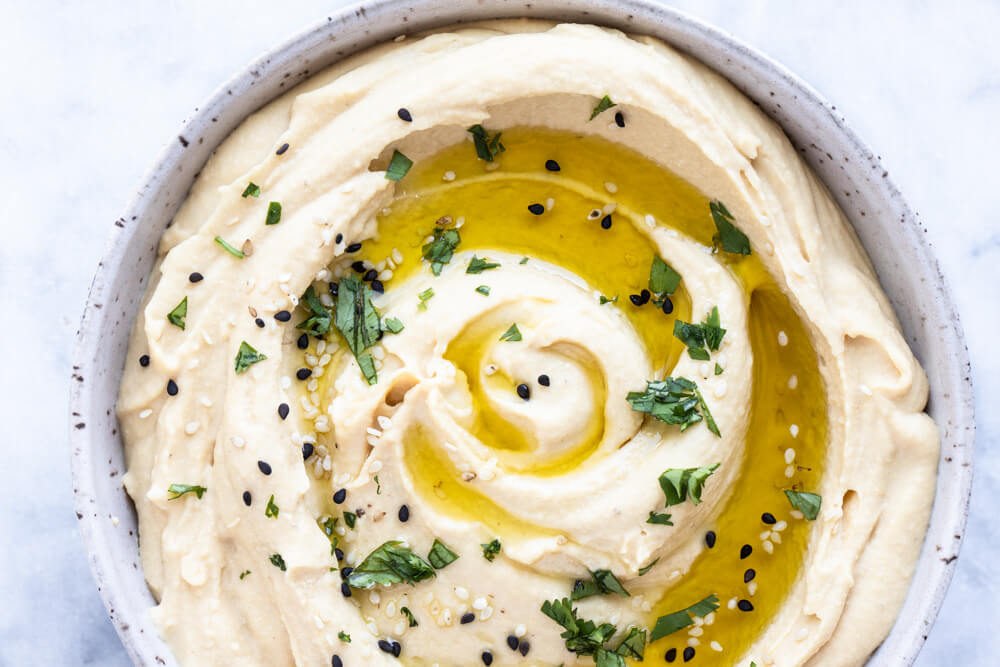 hummus with olive oil and herbs on top