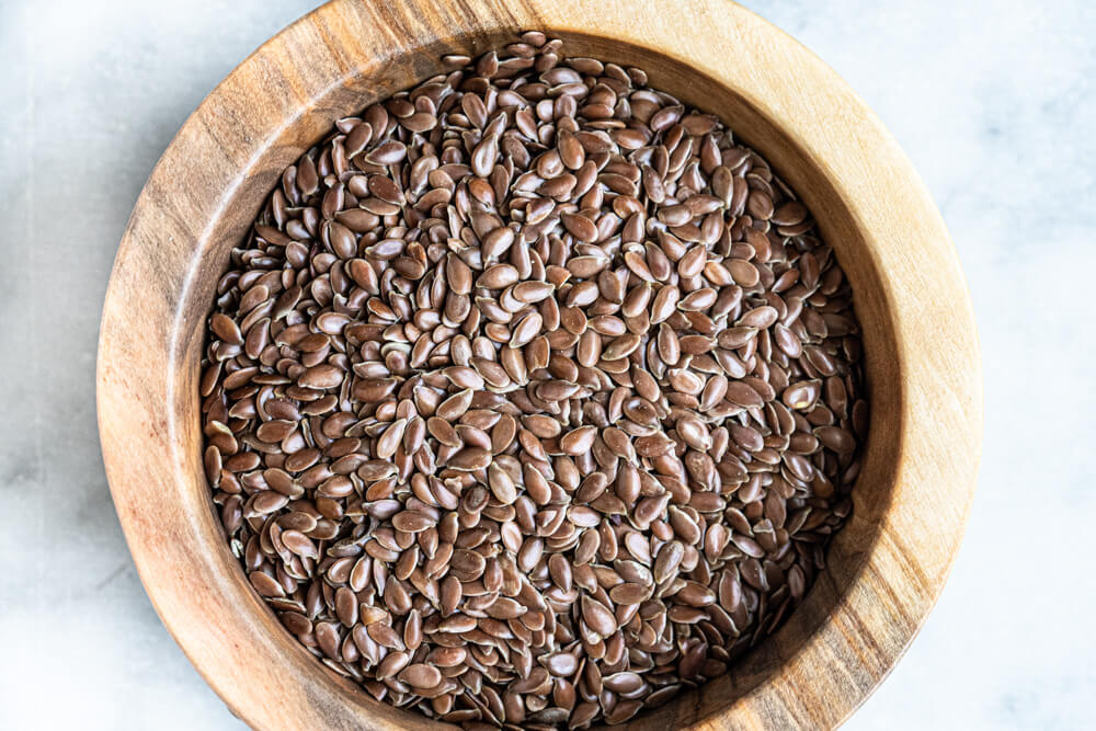 close up of flax seeds in wooden bowl
