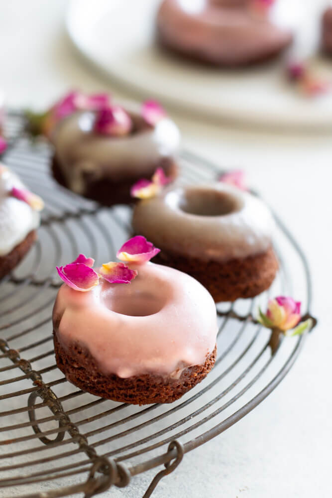 Chocolate Rose Donuts on wire rack on white table
