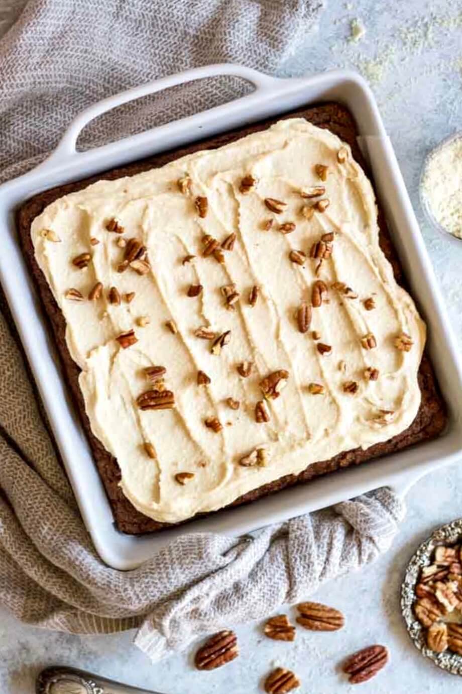 pumpkin cake in white baking dish with nuts on top