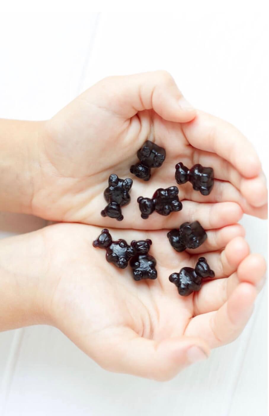 hands holding elderberry gummy bears